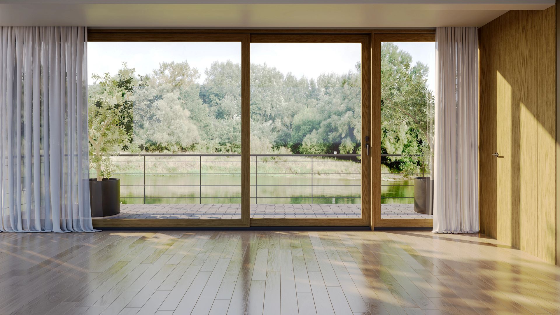 Stanza vuota con grandi porte a vetri che si affacciano su un lago e sugli alberi.