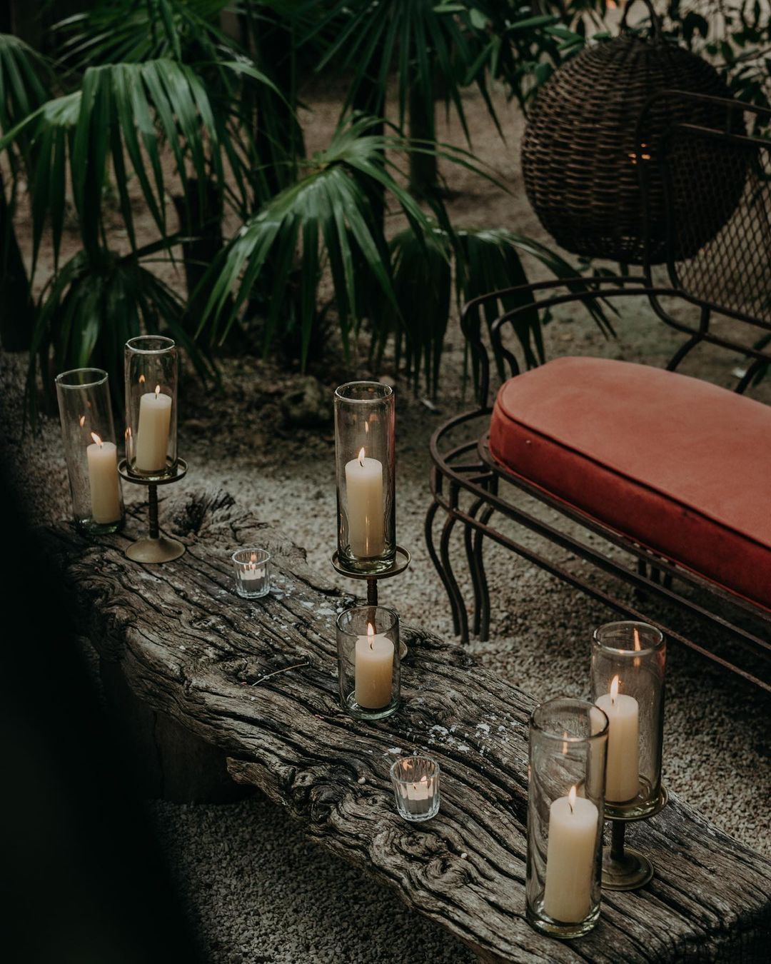 A wooden table topped with candles and a bench.