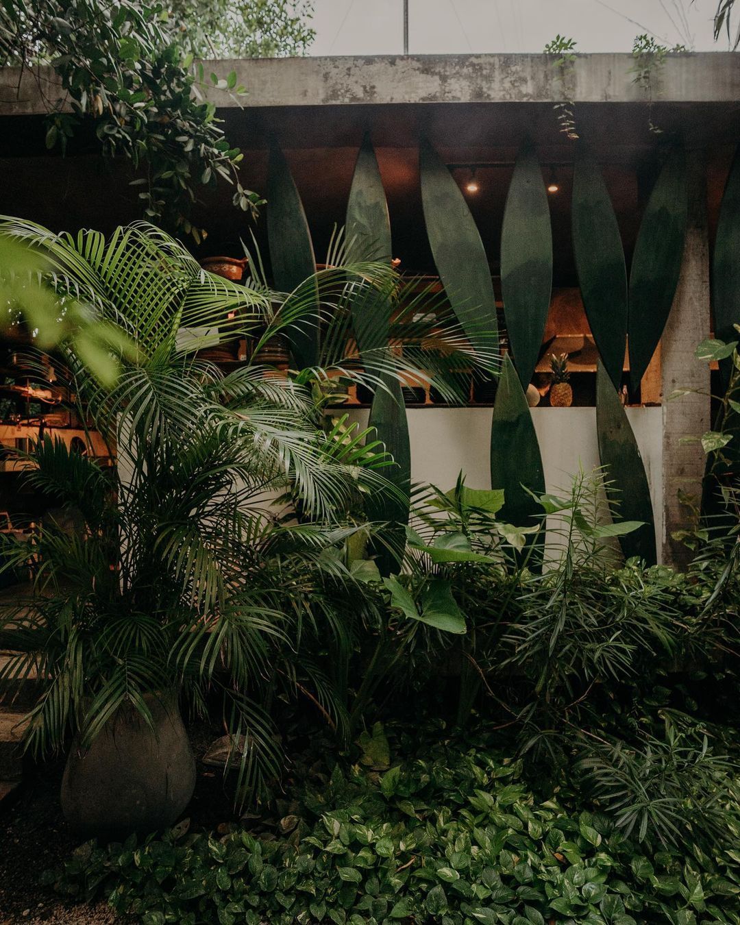 A building with a lot of plants in front of it
