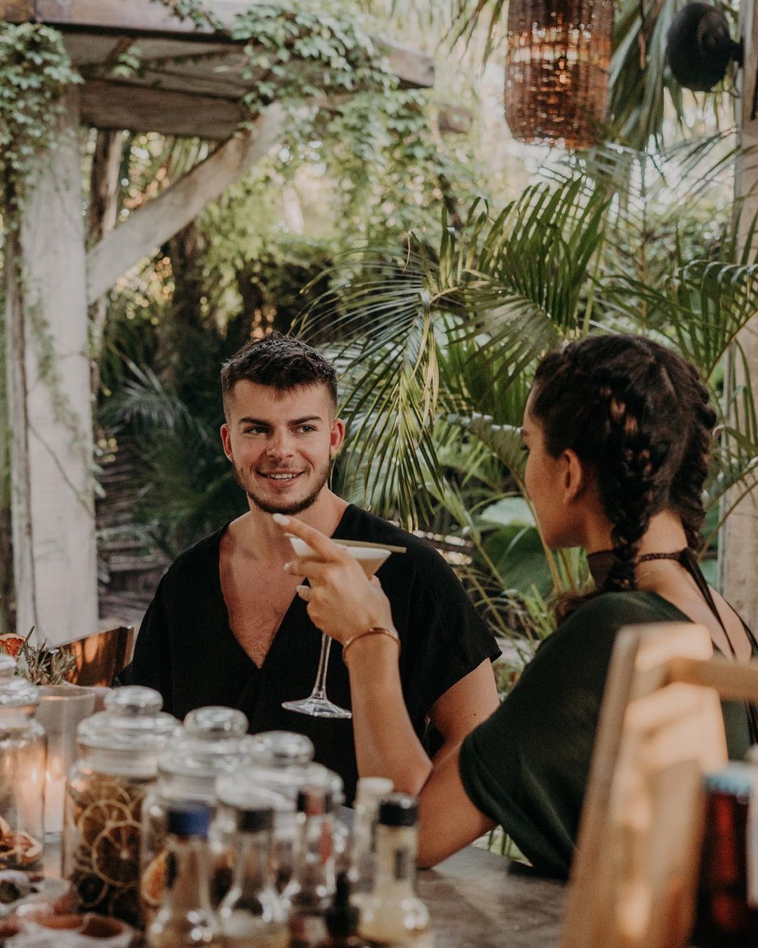 A man and a woman are sitting at a table drinking wine.
