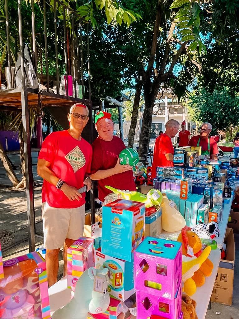 A group of people are standing around a table full of toys.