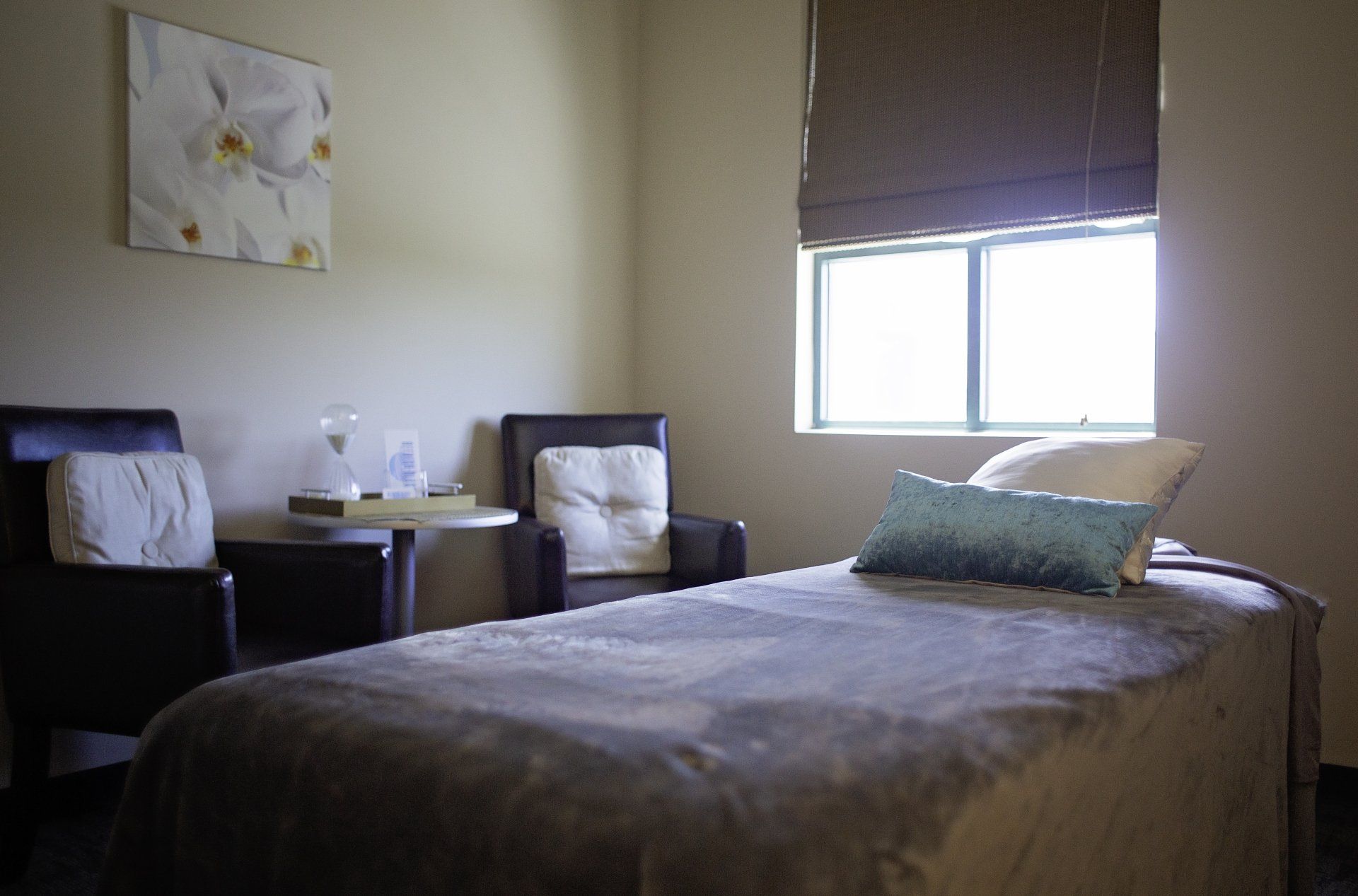 A bedroom with a bed , chairs , a table and a window.