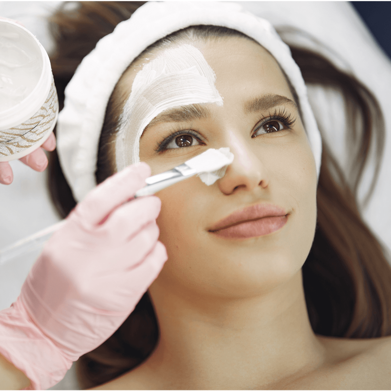 A woman with a bandage on her face is getting a facial treatment