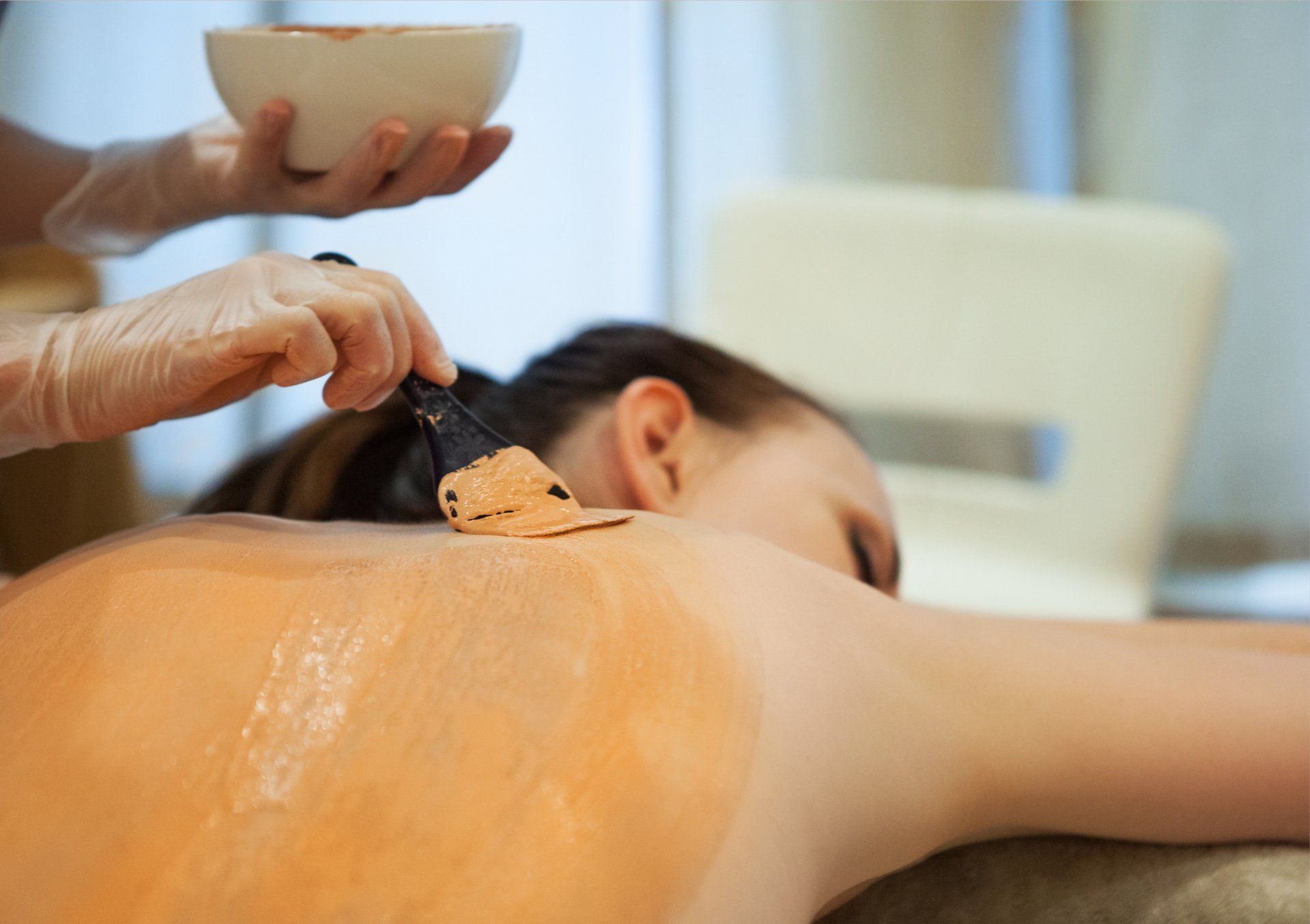 A woman is getting a massage on her back in a spa.