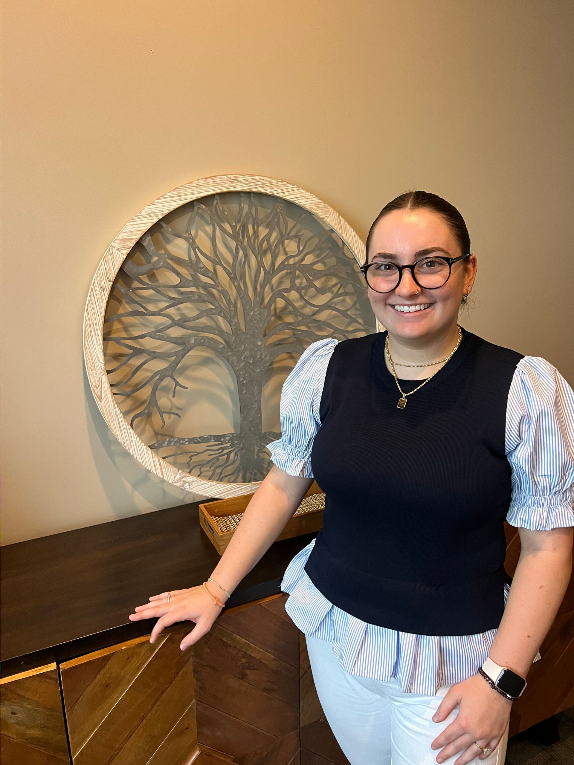A woman standing in front of a metal tree