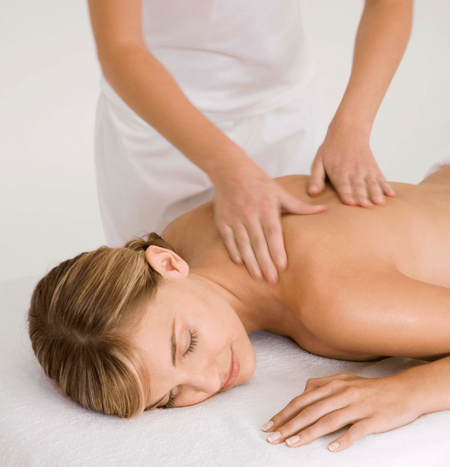 A woman is laying on a table getting a massage