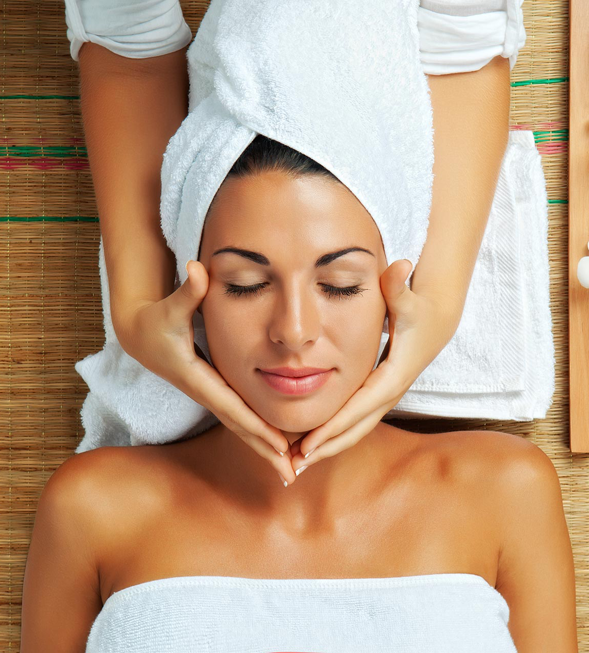 A woman with a towel wrapped around her head is getting a massage