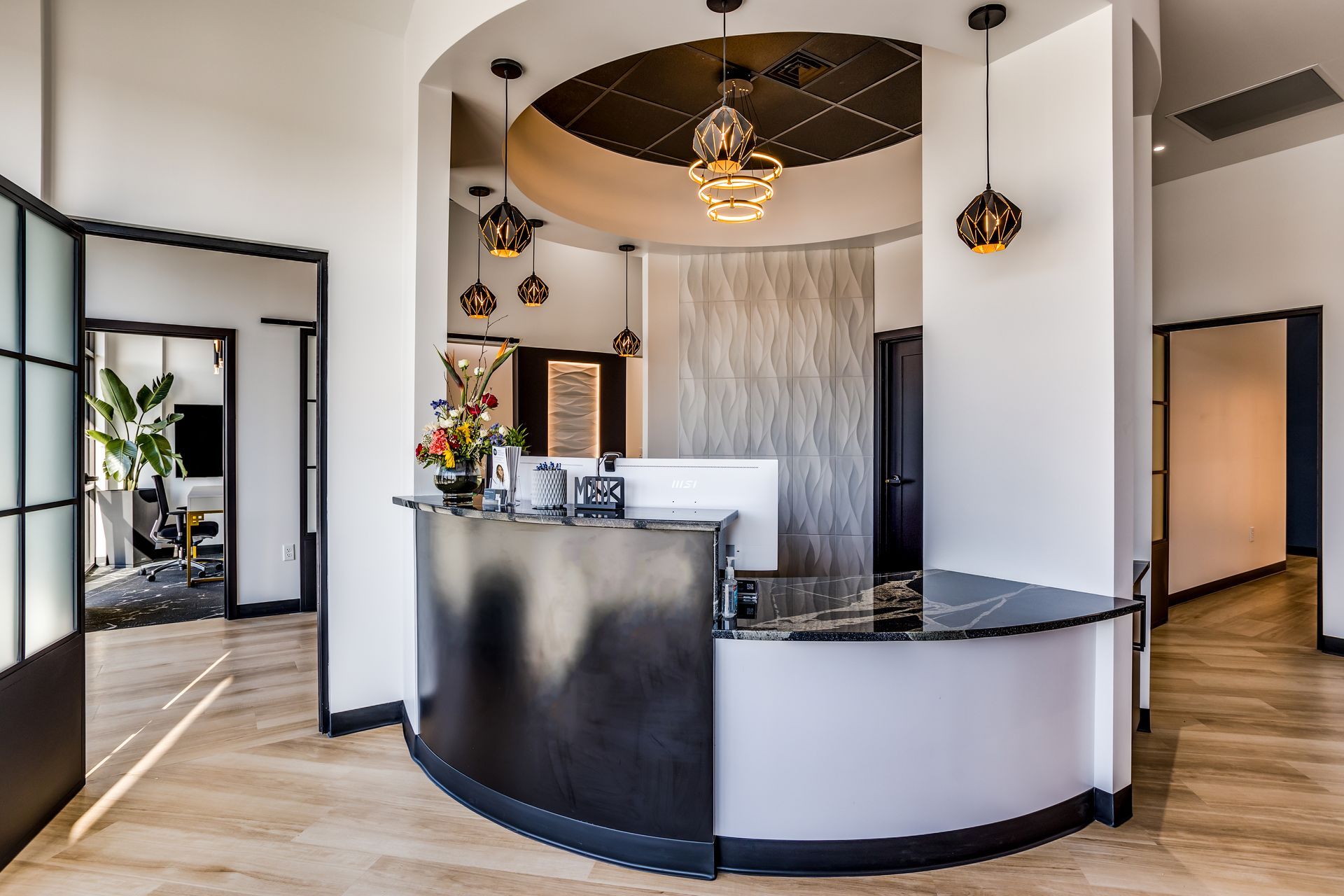 A dental office with a curved reception desk in the middle of the room.