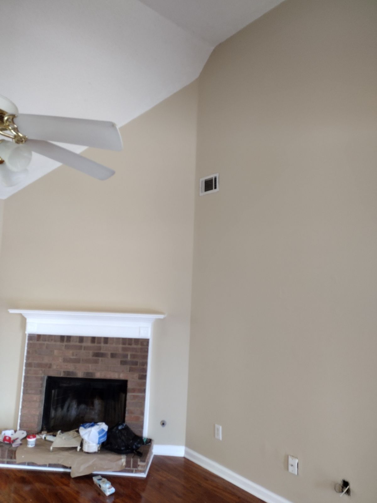 A living room with a fireplace and a ceiling fan