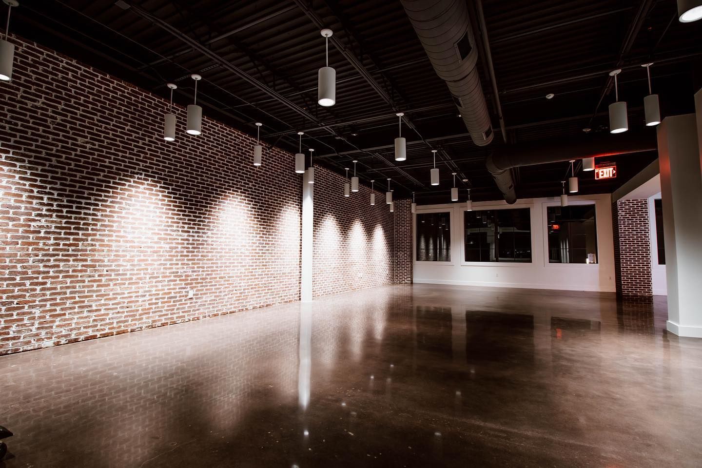 Two people are laying on the grass in a park at sunset.