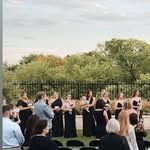 A group of people are standing in front of a fence.