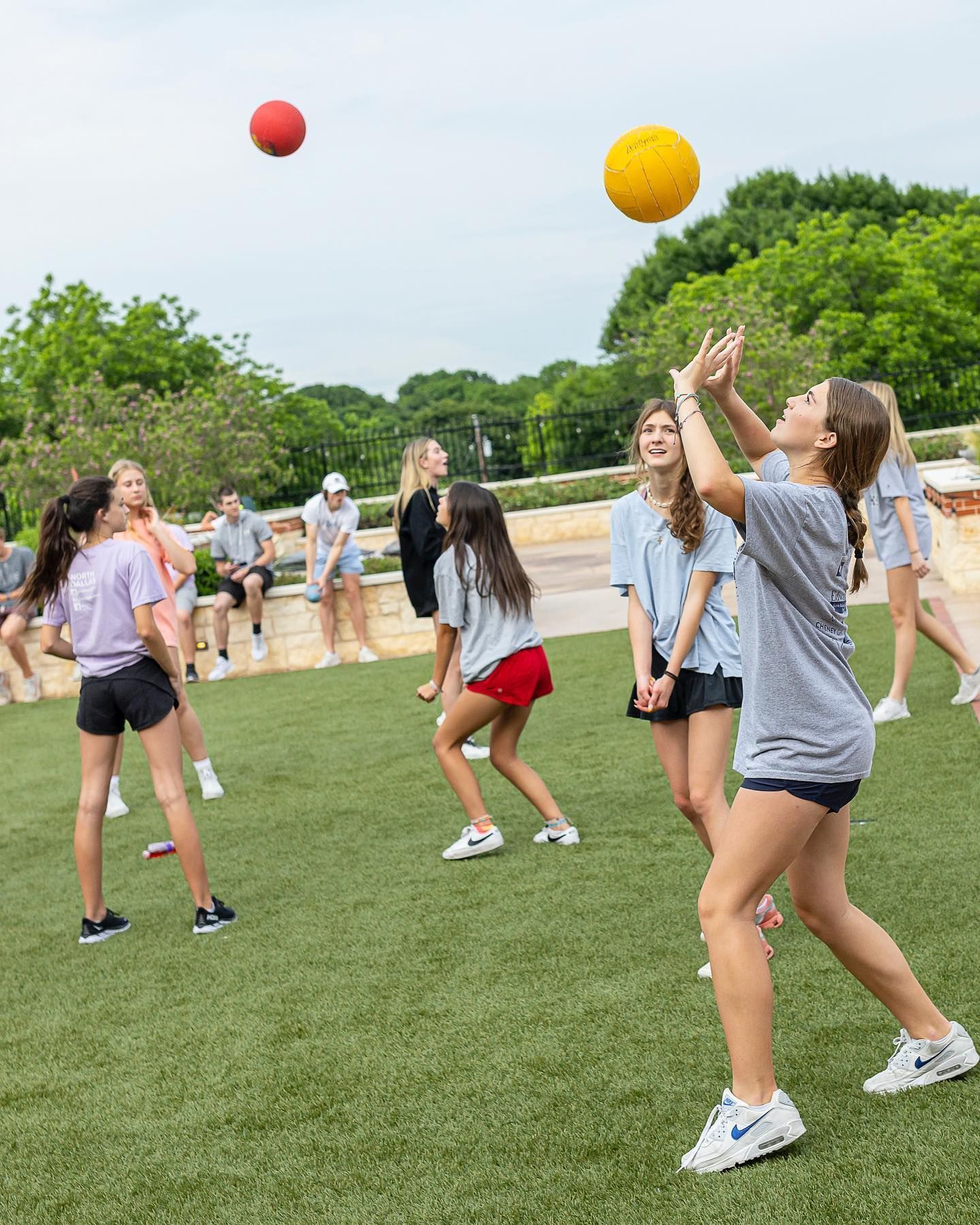 A group of young girls are playing volleyball on a field.