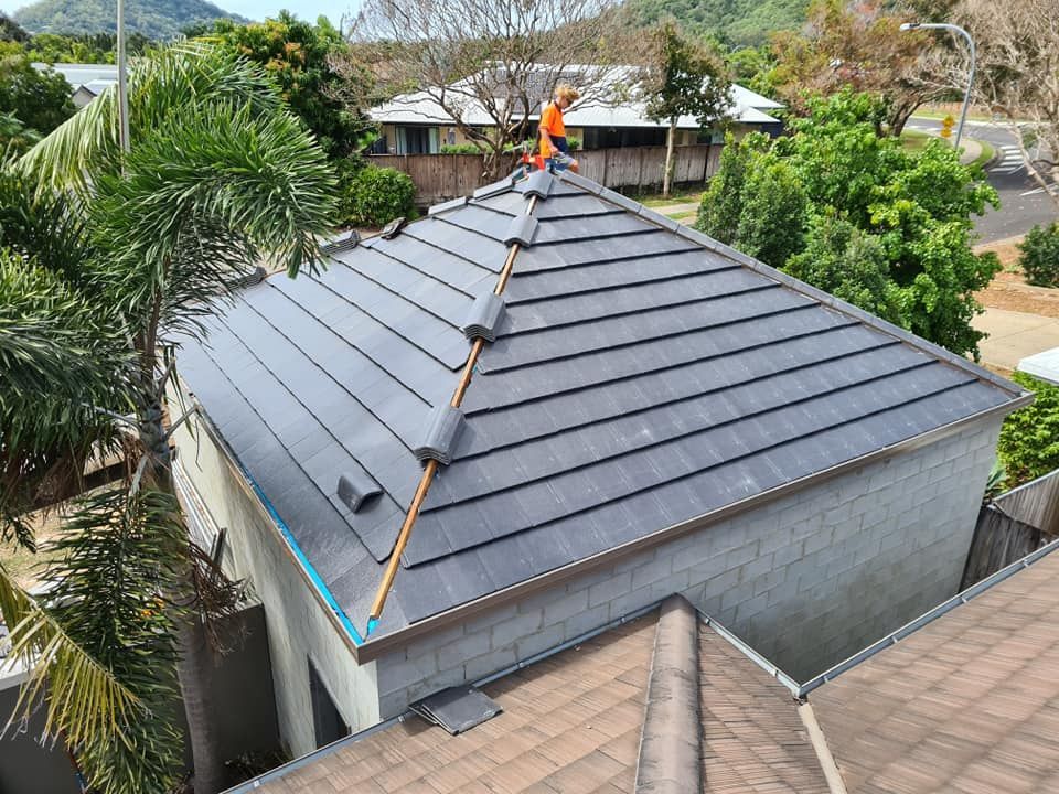 Roofer in Orange Safety Gear Working on A Dark Gray Tiled Roof — High Performance Roof Tiling P/L in Kewarra Beach, QLD