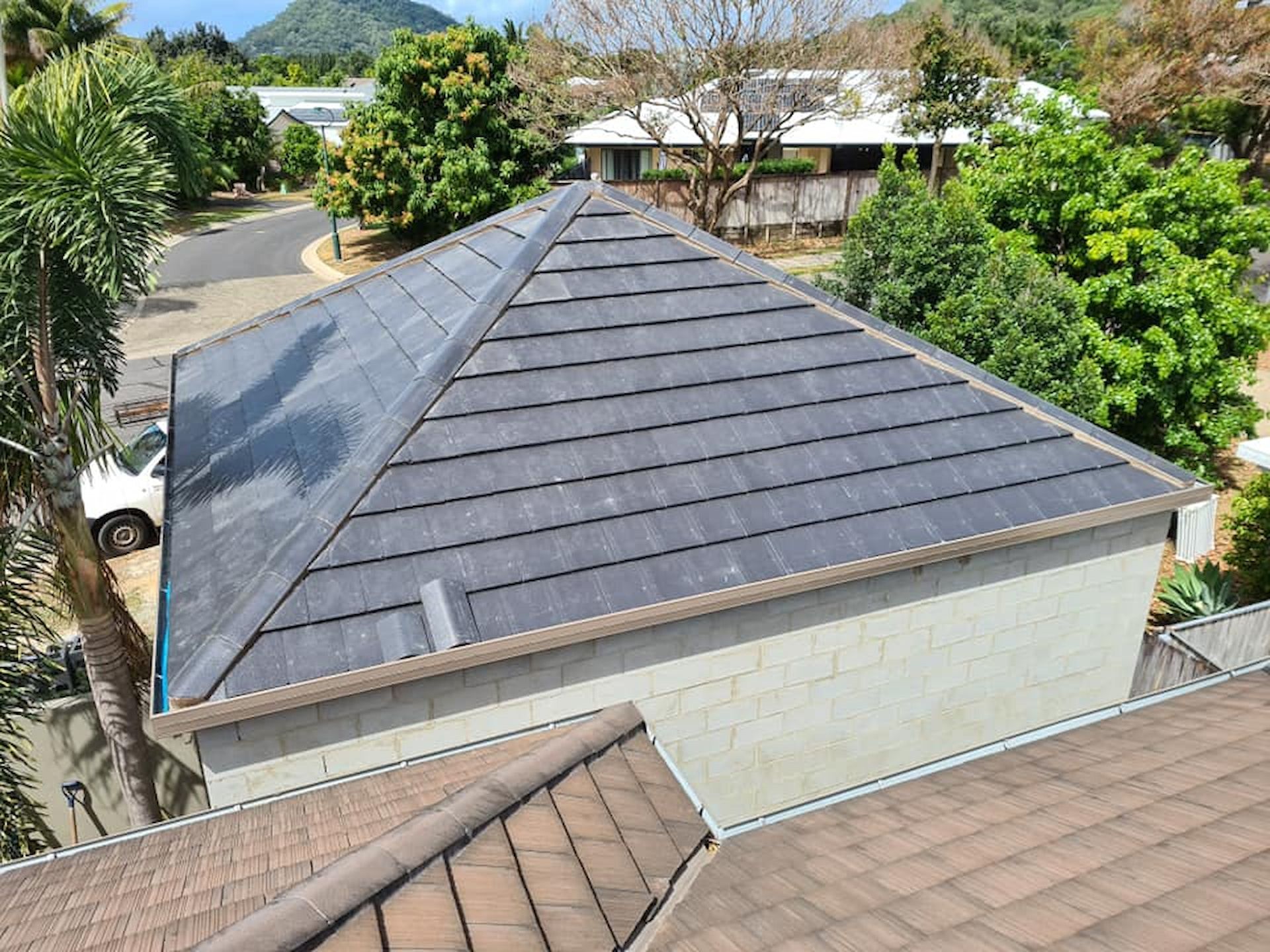 Gray Tiled Roof of A House, Surrounded by Trees — High Performance Roof Tiling P/L in Kewarra Beach, QLD
