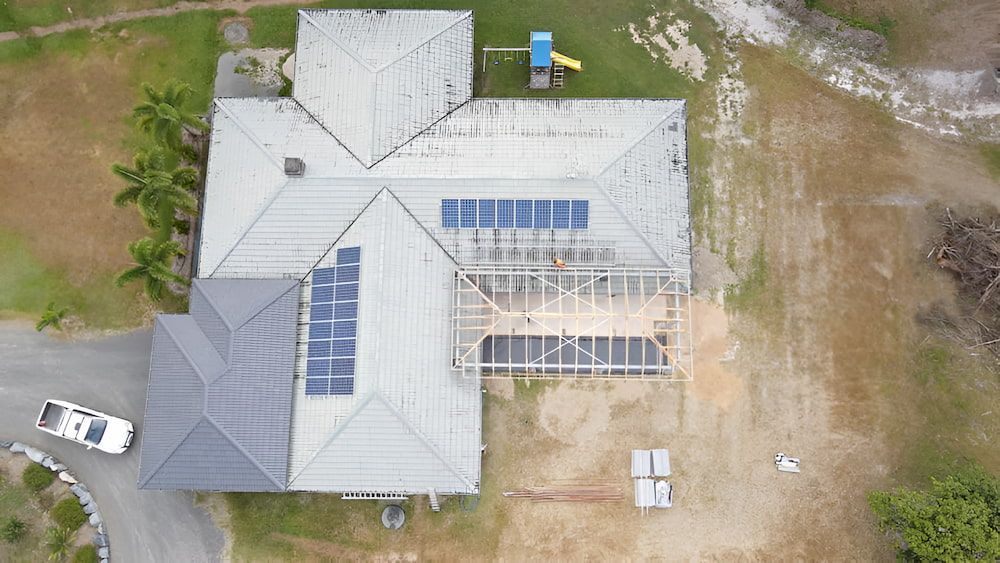 An Aerial View of a House With Solar Panels on the Roof — High Performance Roof Tiling P/L in Kewarra Beach, QLD