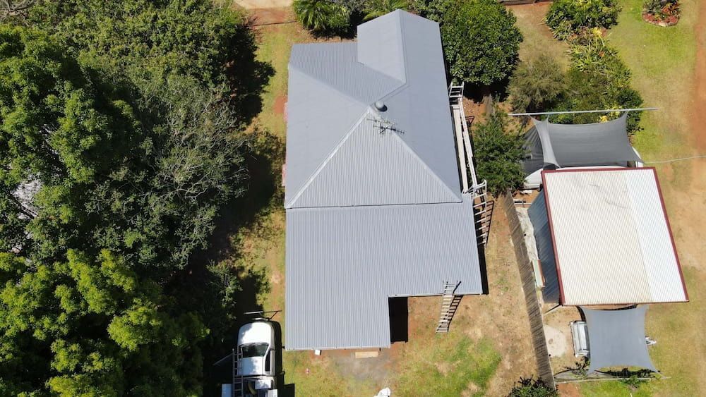 Aerial View of a House With a Truck Parked in Front of It — High Performance Roof Tiling P/L in Tully, QLD
