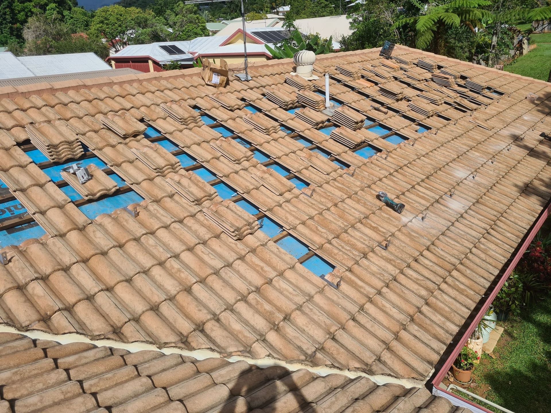 Rooftop with Missing Tiles Exposing Blue Underlayment, in A Sunny Setting — High Performance Roof Tiling P/L in Kewarra Beach, QLD