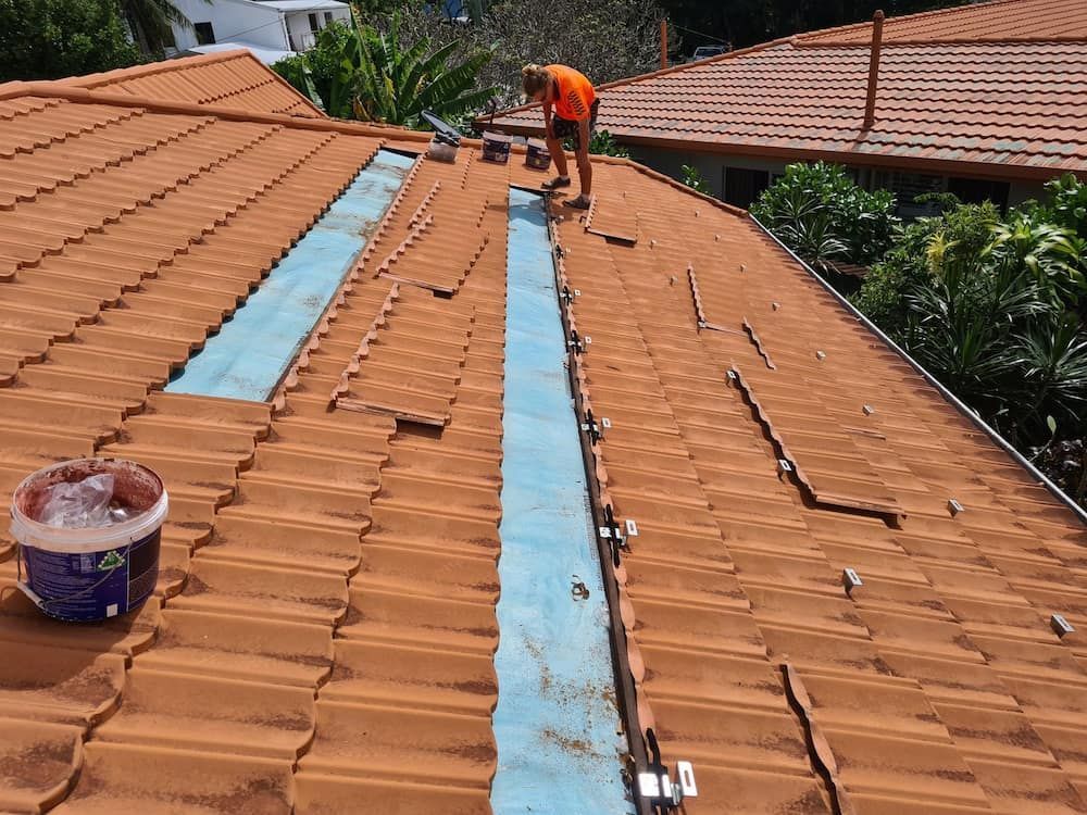 Man is Working on the Roof of a House — High Performance Roof Tiling P/L in Innisfail, QLD
