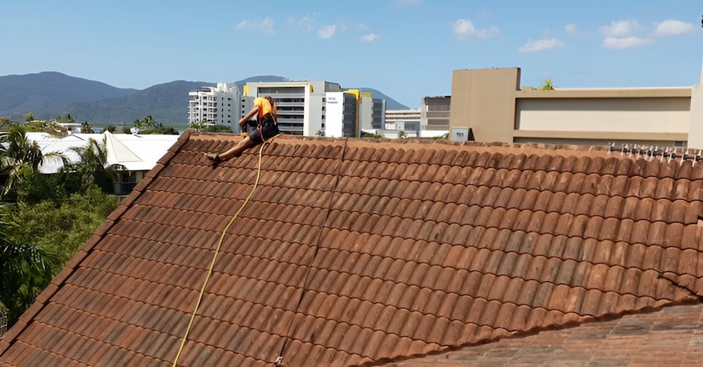 Person Rappelling Down a Red Tiled Roof — High Performance Roof Tiling P/L in Kewarra Beach, QLD