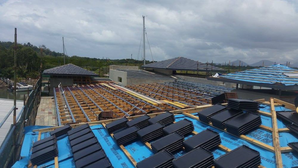 A Roof of a Building Under Construction With a Blue Tarp on It — High Performance Roof Tiling P/L in Kewarra Beach, QLD