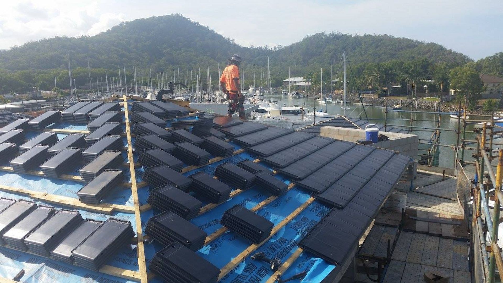 Workers Installing Black Solar Panels on A Roof — High Performance Roof Tiling P/L in Kewarra Beach, QLD
