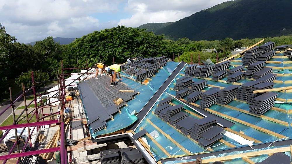A Group of People Are Working on the Roof of a Building — High Performance Roof Tiling P/L in Mossman, QLD