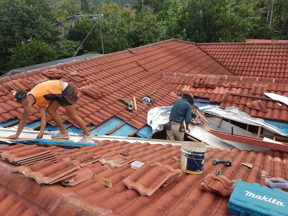 Two Men Are Working on the Roof of a House — High Performance Roof Tiling P/L in Mossman, QLD