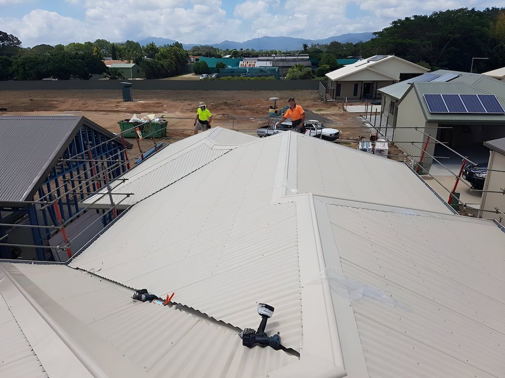 A Group of People Are Working on the Roof of a House — High Performance Roof Tiling P/L in Kewarra Beach, QLD