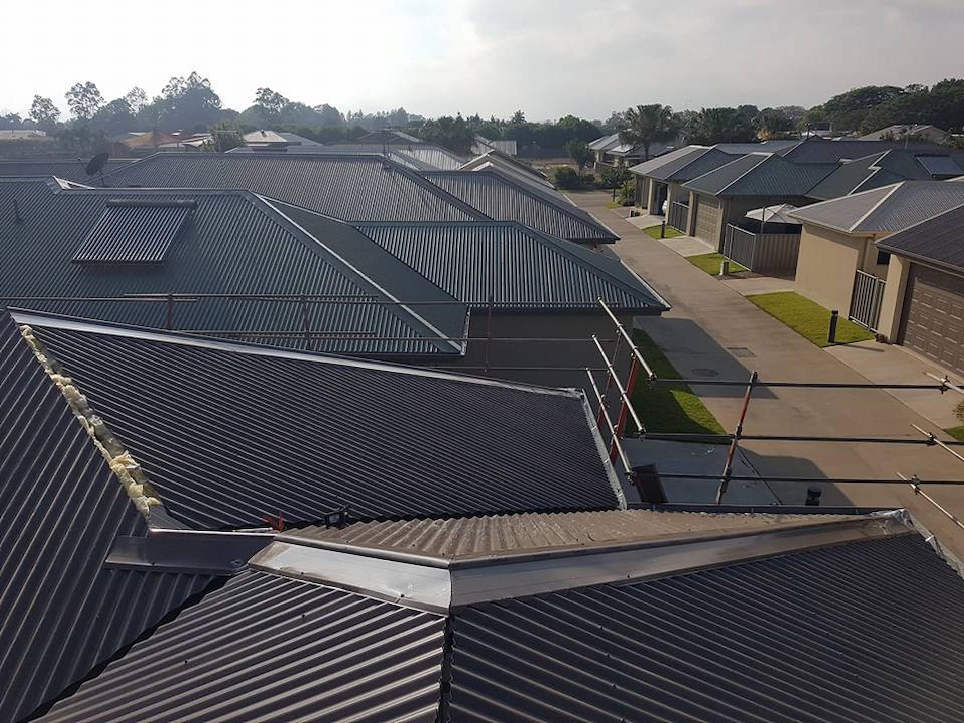 Overhead View of Several Dark Metal Roofs in A Residential — High Performance Roof Tiling P/L in Kewarra Beach, QLD