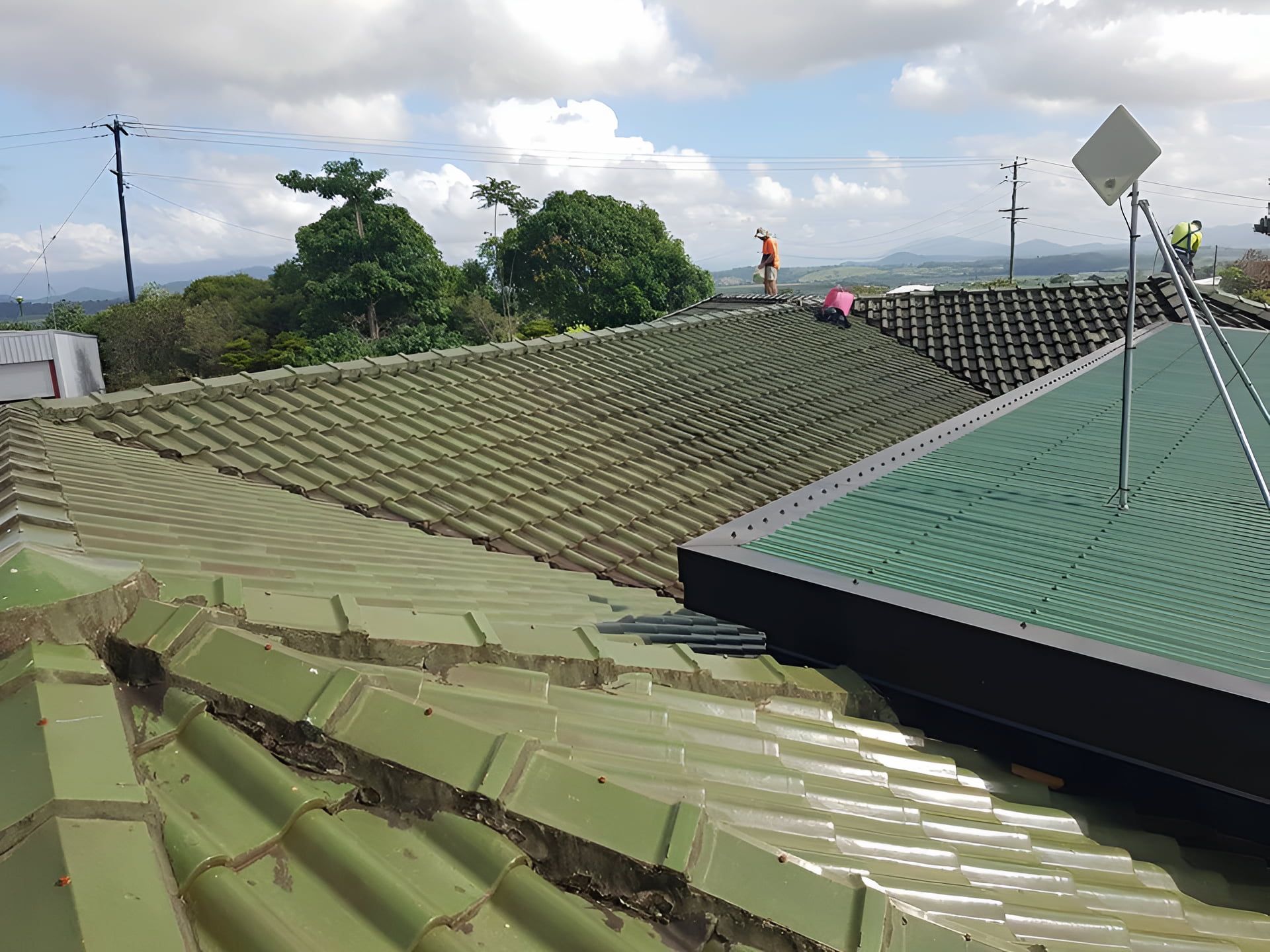 Green Tiled Roofs with Workers, Trees, and Sky in The Background — High Performance Roof Tiling P/L in Kewarra Beach, QLD