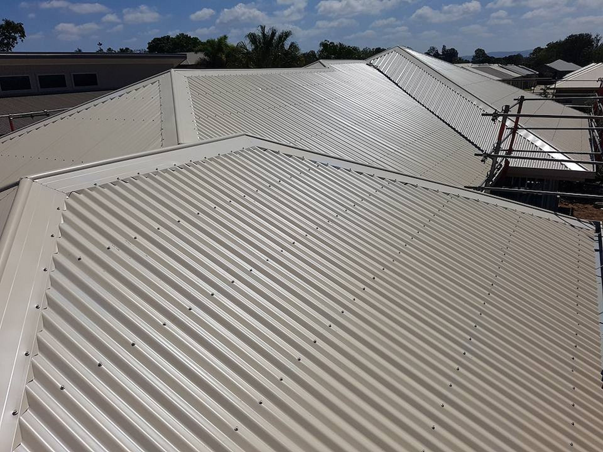 Beige Corrugated Metal Roofing on A Residential Building — High Performance Roof Tiling P/L in Kewarra Beach, QLD