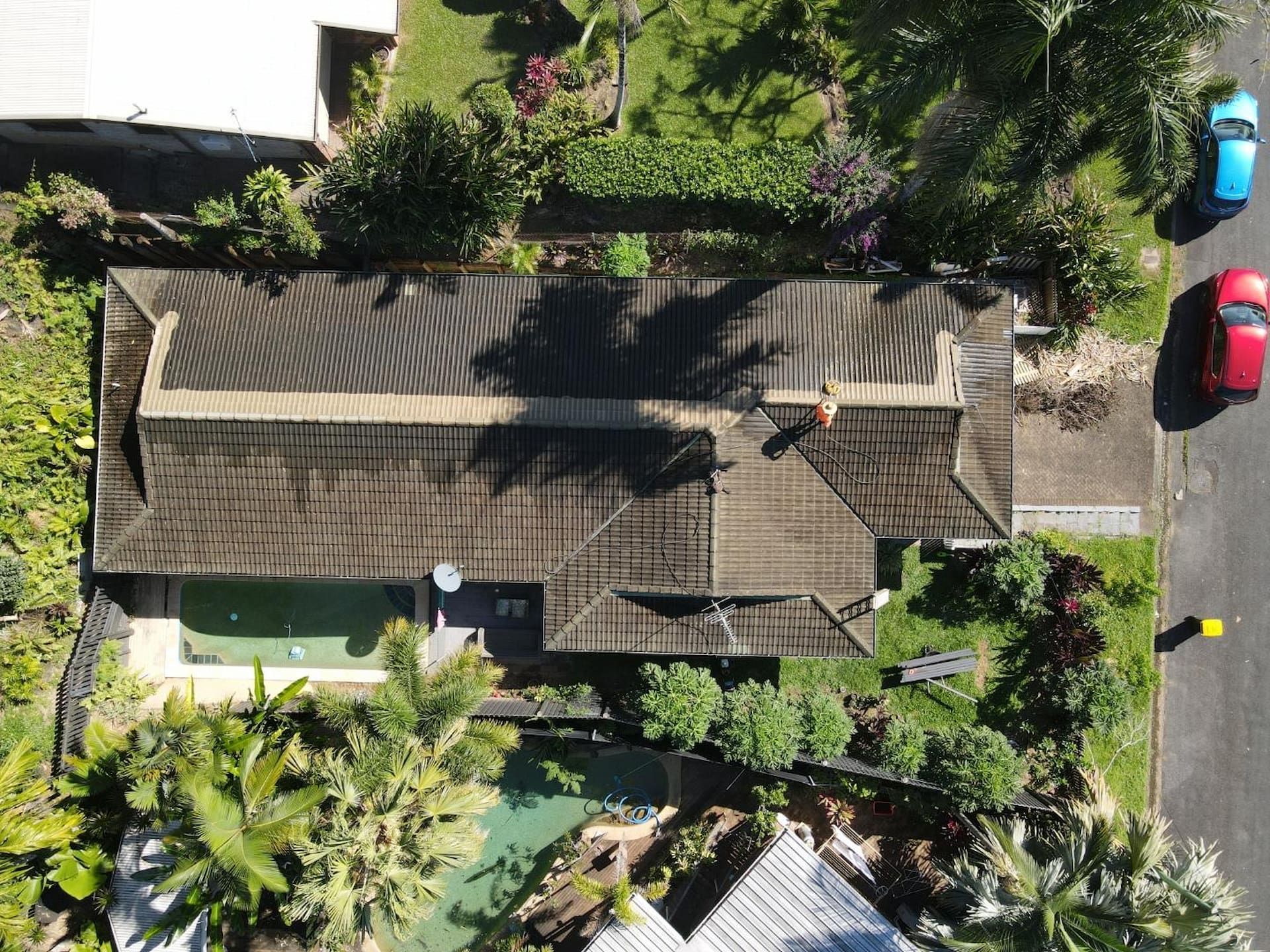 Overhead View of A House with A Dark Roof, Surrounded by Green Trees — High Performance Roof Tiling P/L in Kewarra Beach, QLD