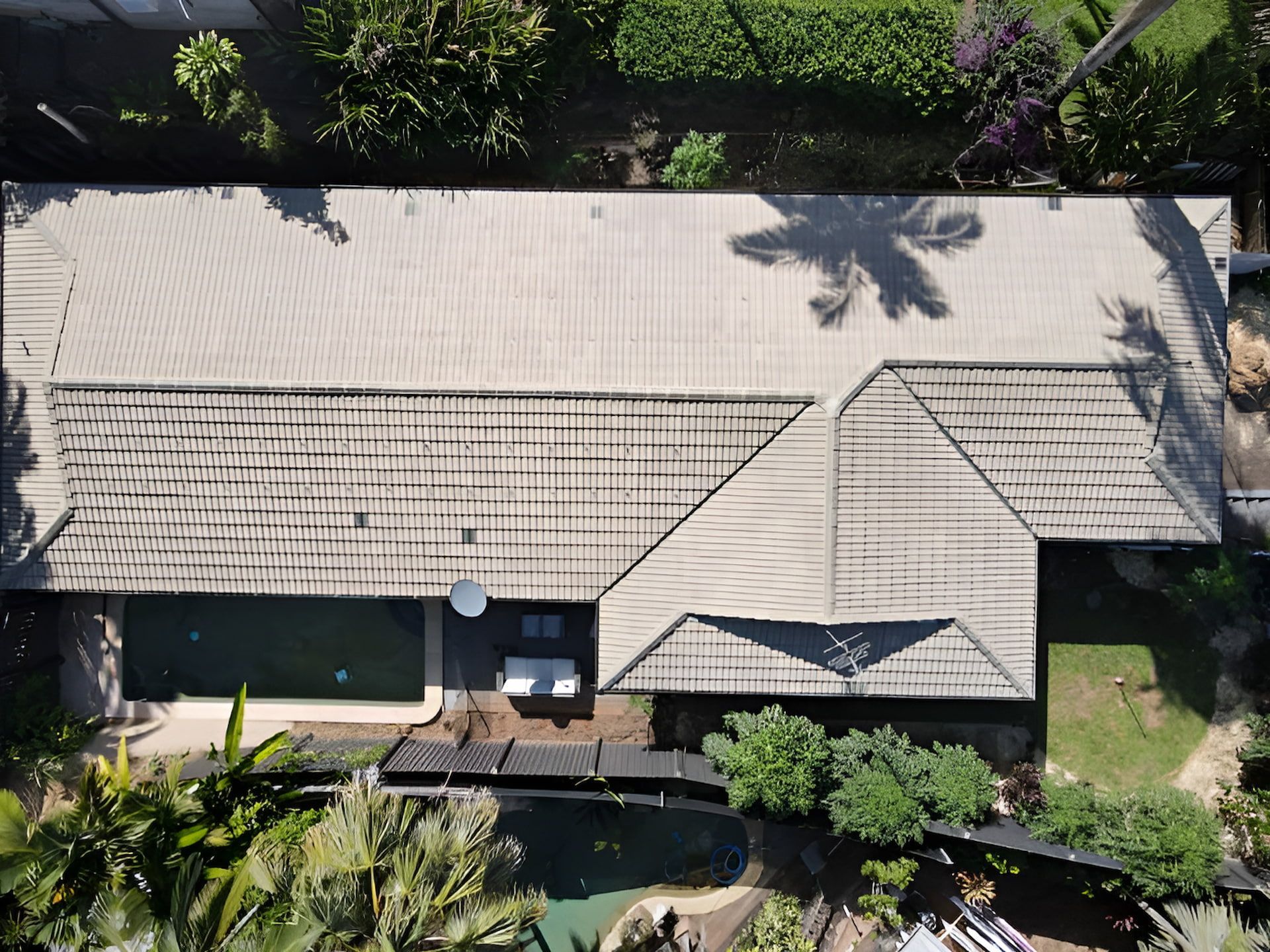 Aerial View of A House with A Tan Tile Roof and Surrounding Green Yard and Trees — High Performance Roof Tiling P/L in Kewarra Beach, QLD