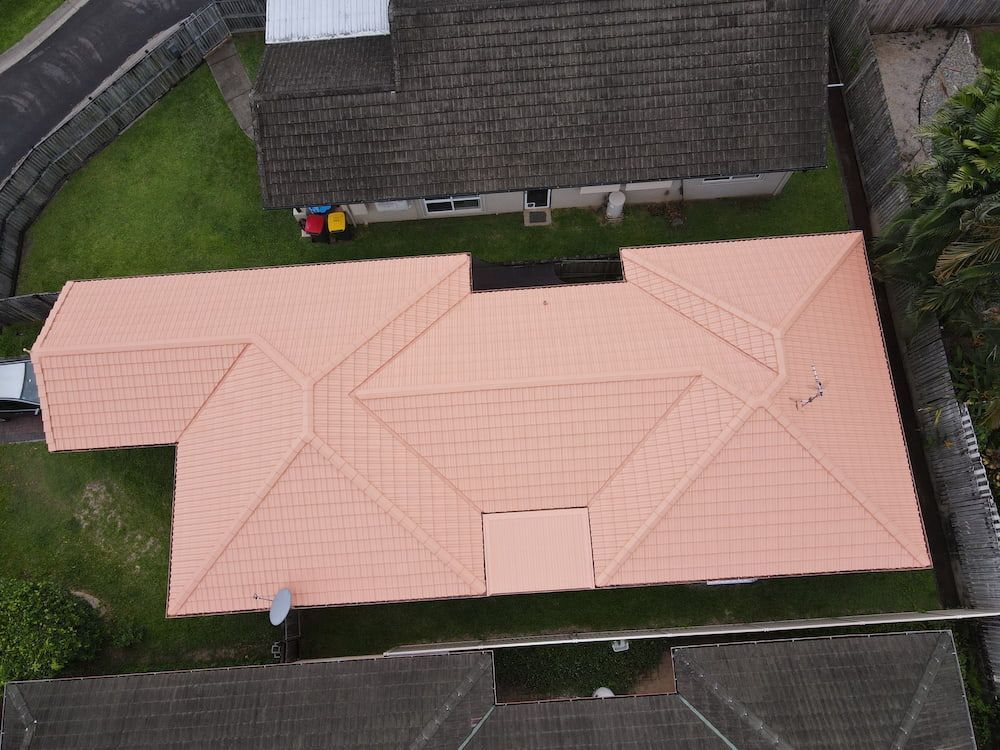 Aerial View of A House with A Pink Roof, Surrounded by Green Grass — High Performance Roof Tiling P/L in Kewarra Beach, QLD