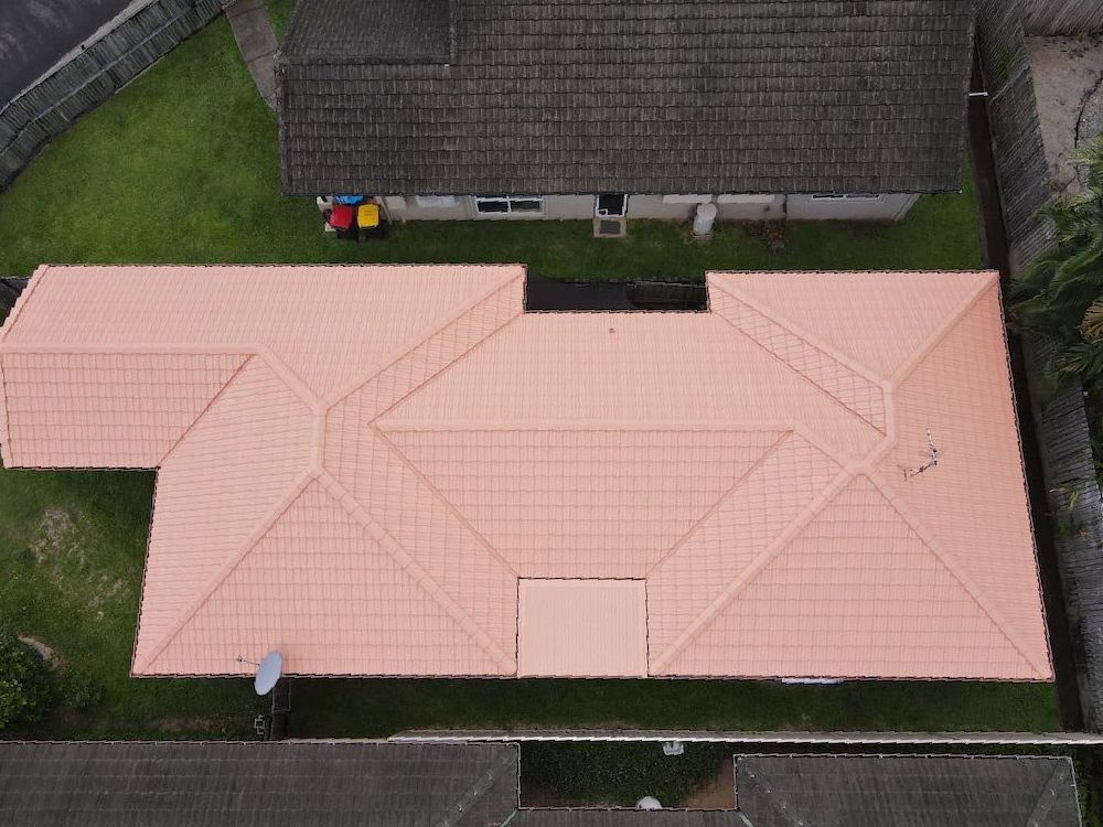 An Aerial View of a House With a Pink Roof — High Performance Roof Tiling P/L in Kewarra Beach, QLD