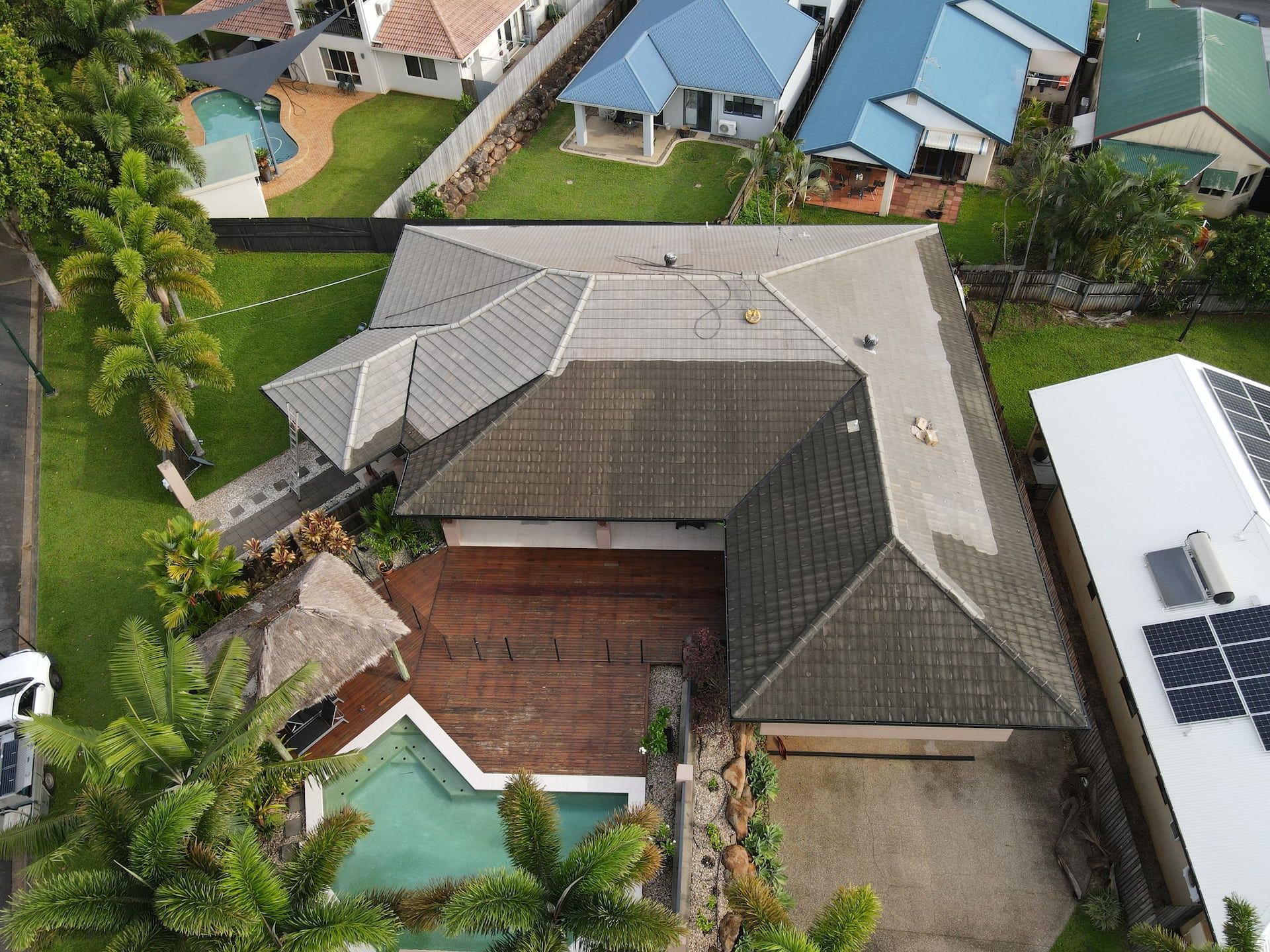 Overhead View of A House with A Tiled Roof, Driveway, Pool, and Surrounding Houses — High Performance Roof Tiling P/L in Kewarra Beach, QLD
