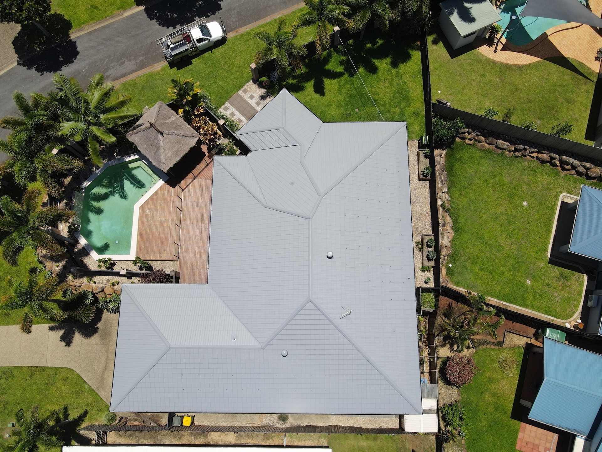 Aerial View of A House with A Gray Roof, Pool, and Surrounding Greenery — High Performance Roof Tiling P/L in Kewarra Beach, QLD