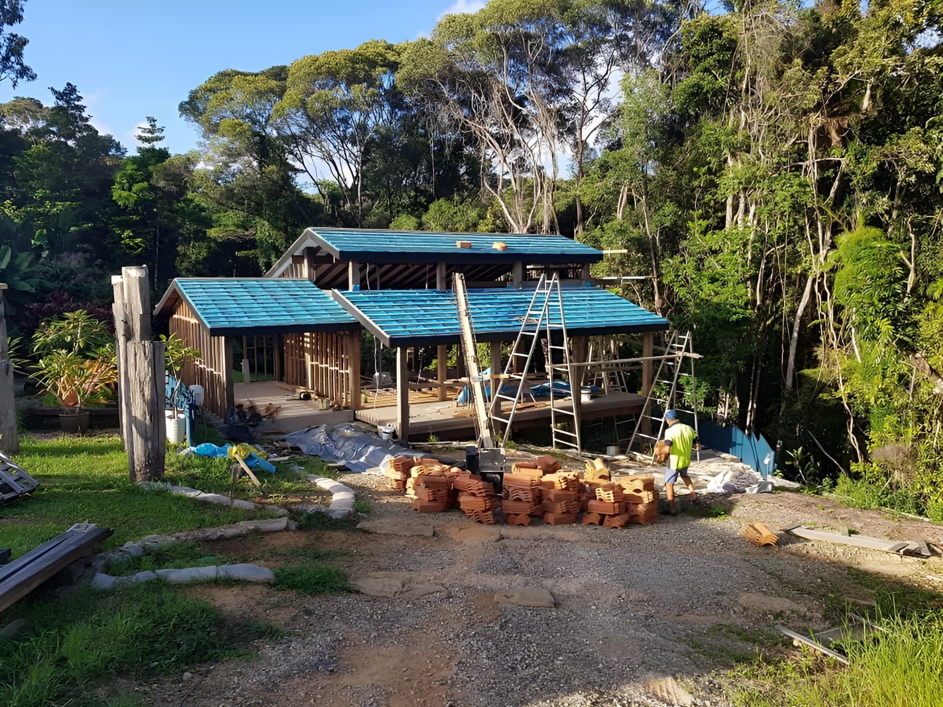 Construction of A Wooden Building with A Teal Roof in A Lush — High Performance Roof Tiling P/L in Kewarra Beach, QLD