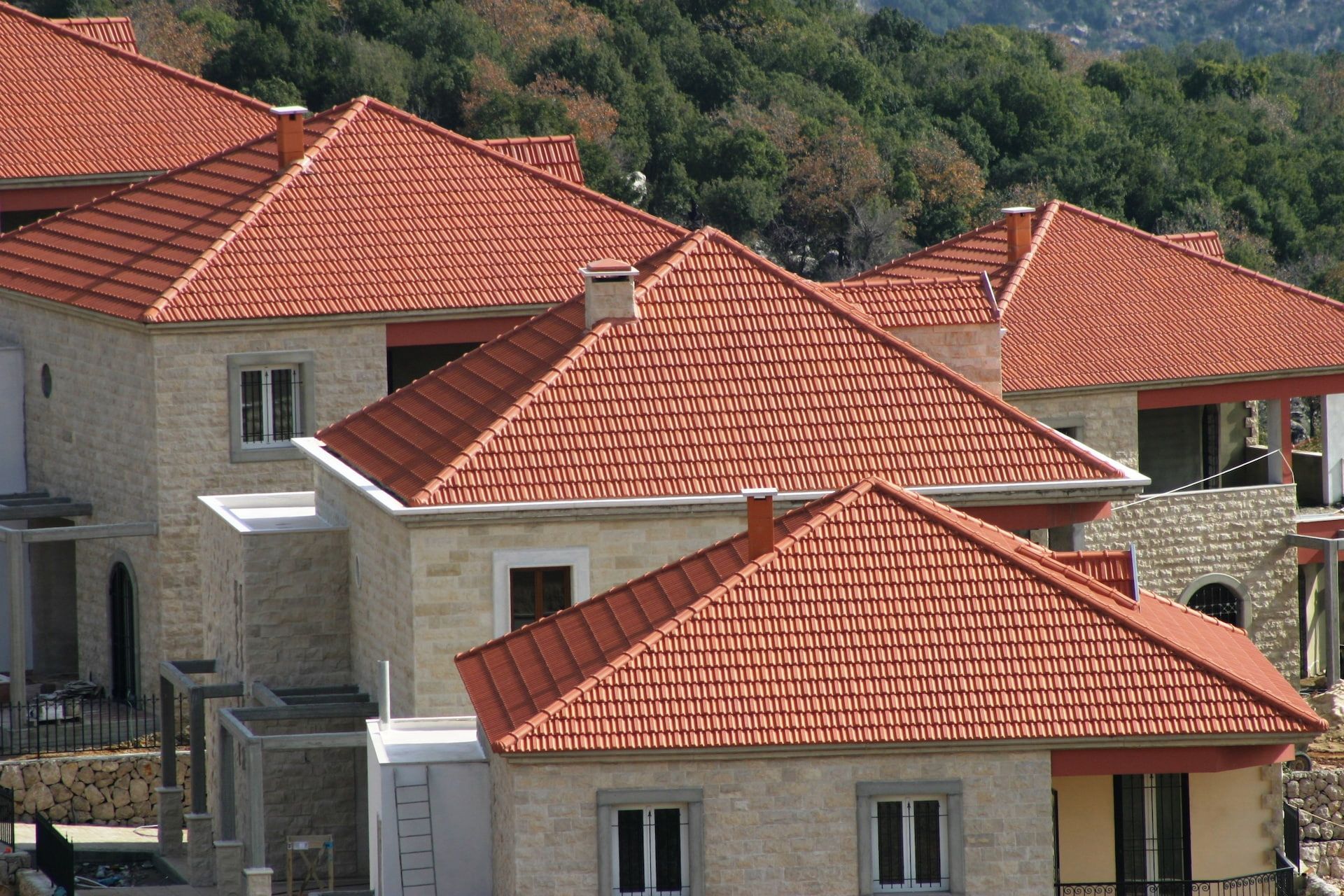 Row of Light-Colored Stone Houses with Red Tile Roofs — High Performance Roof Tiling P/L in Kewarra Beach, QLD