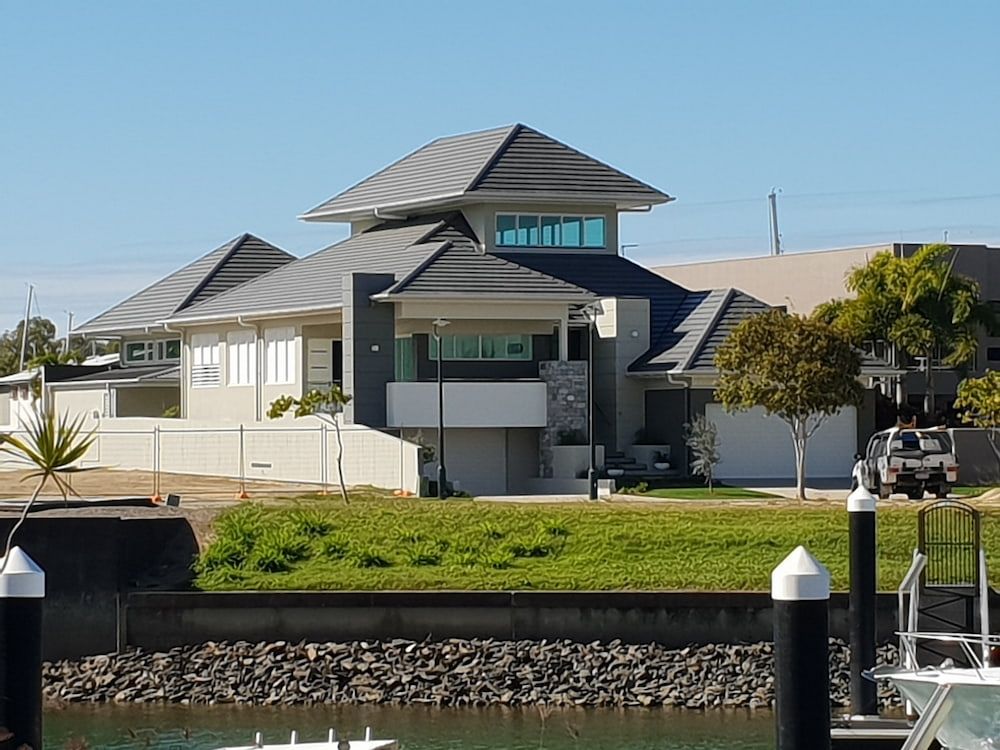 Modern Waterfront Home with Gray Roof and Light-Colored Walls — High Performance Roof Tiling P/L in Kewarra Beach, QLD