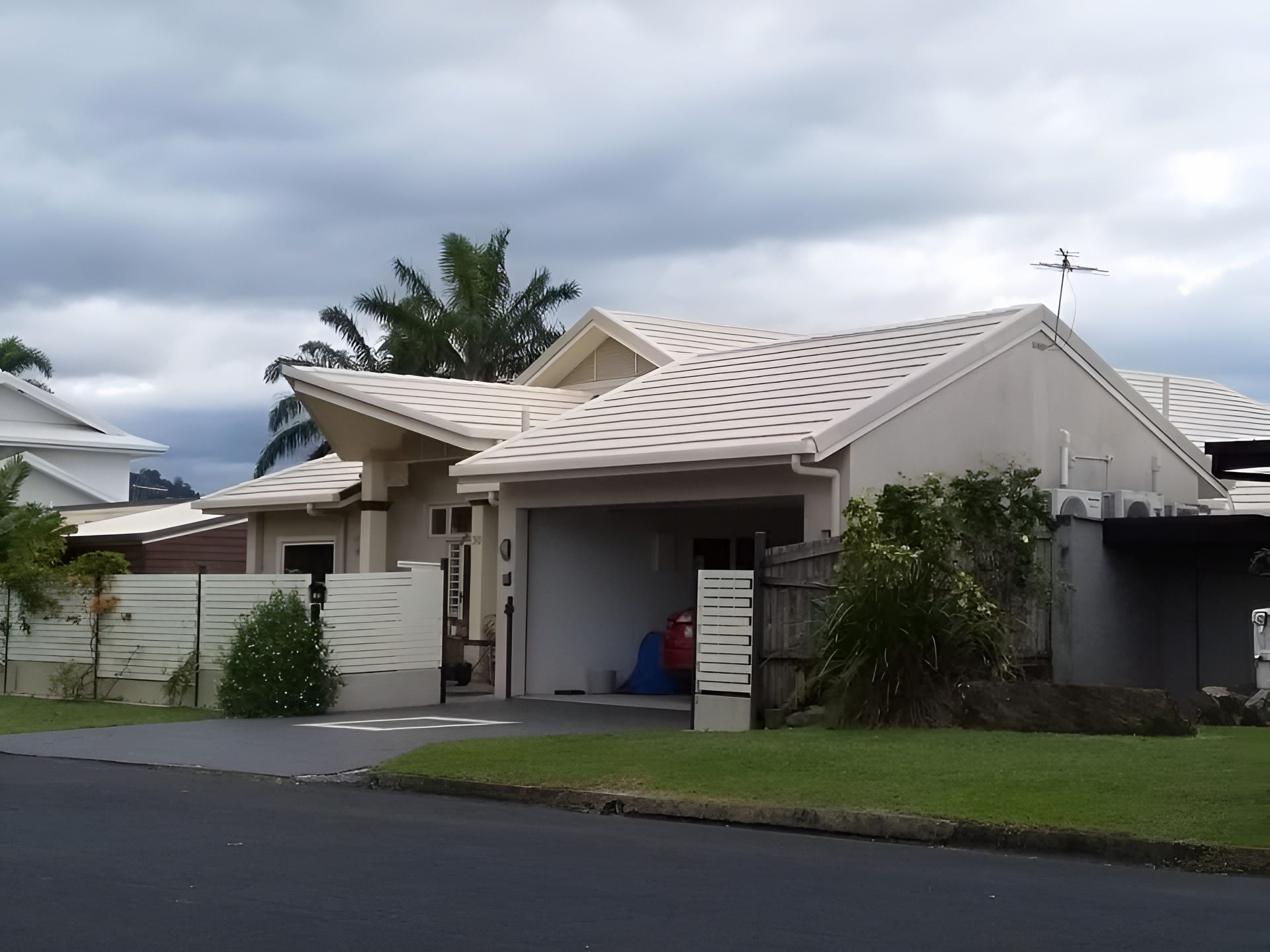 Tan House with A Light-Colored Roof, a Driveway, and A Cloudy Sky — High Performance Roof Tiling P/L in Kewarra Beach, QLD