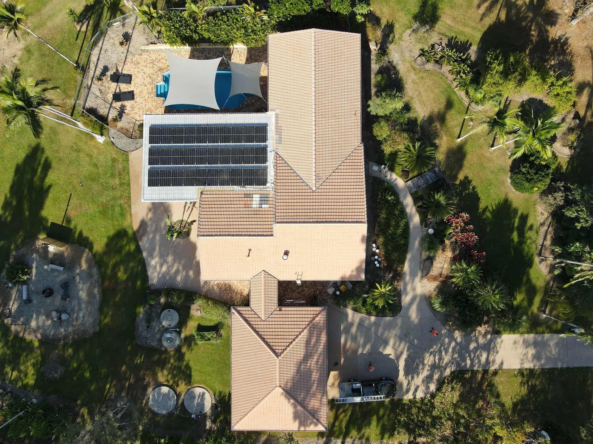 Aerial View of A Home with Solar Panels, a Pool, and A Circular Patio — High Performance Roof Tiling P/L in Kewarra Beach, QLD