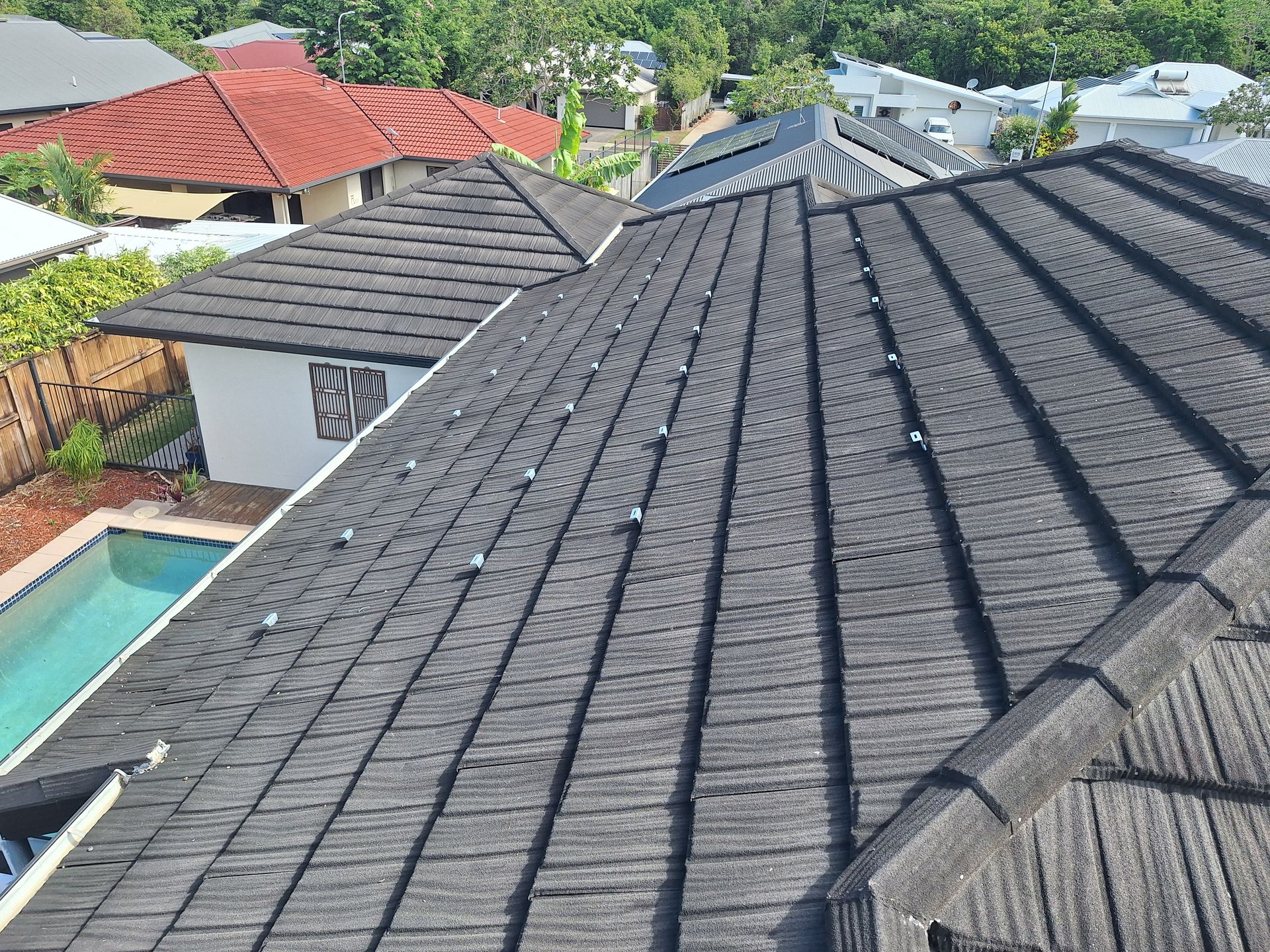 Dark Gray Metal Roof of A House with Several Visible Fasteners — High Performance Roof Tiling P/L in Kewarra Beach, QLD