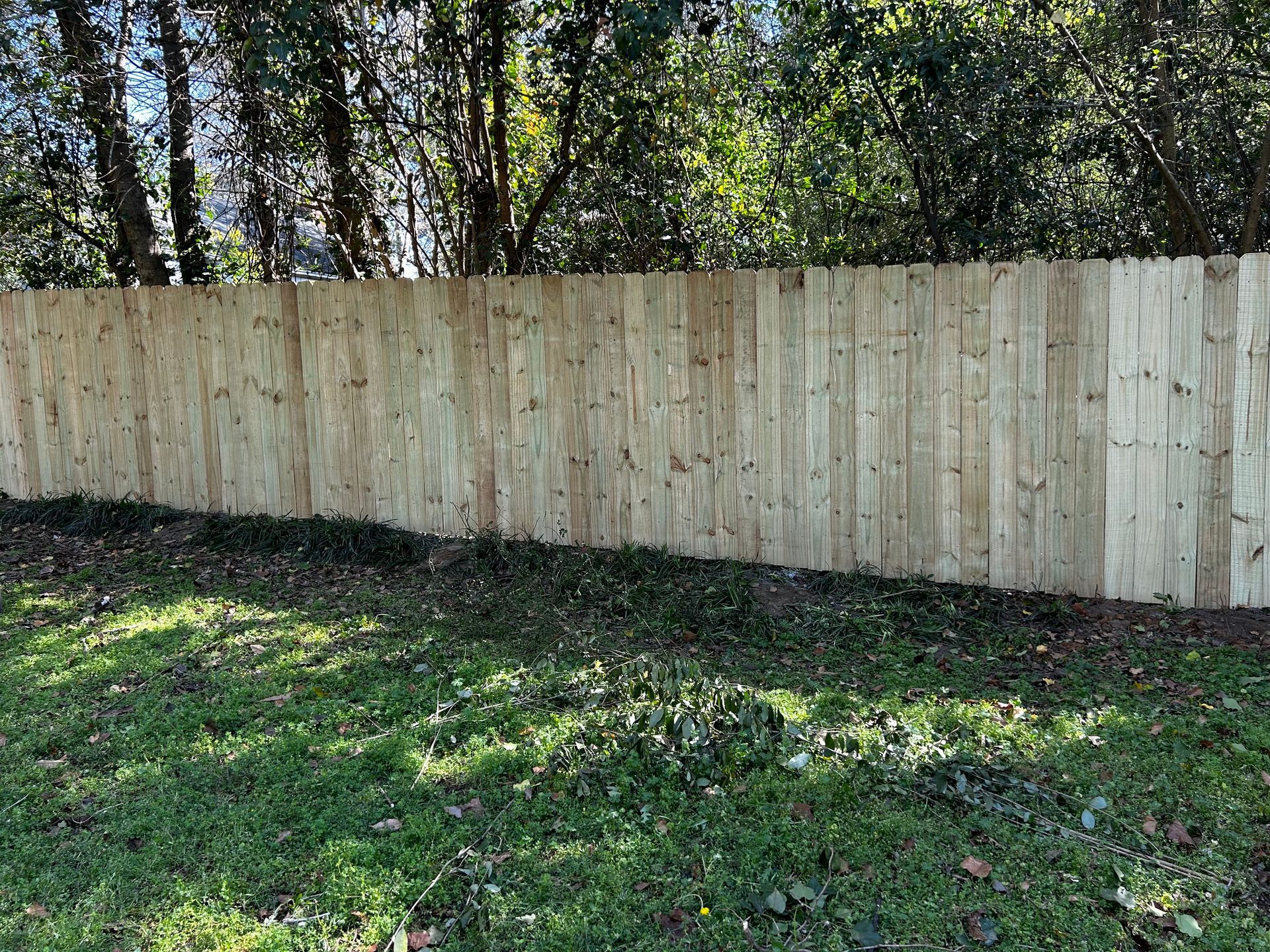 A wooden fence is sitting in the middle of a lush green field.