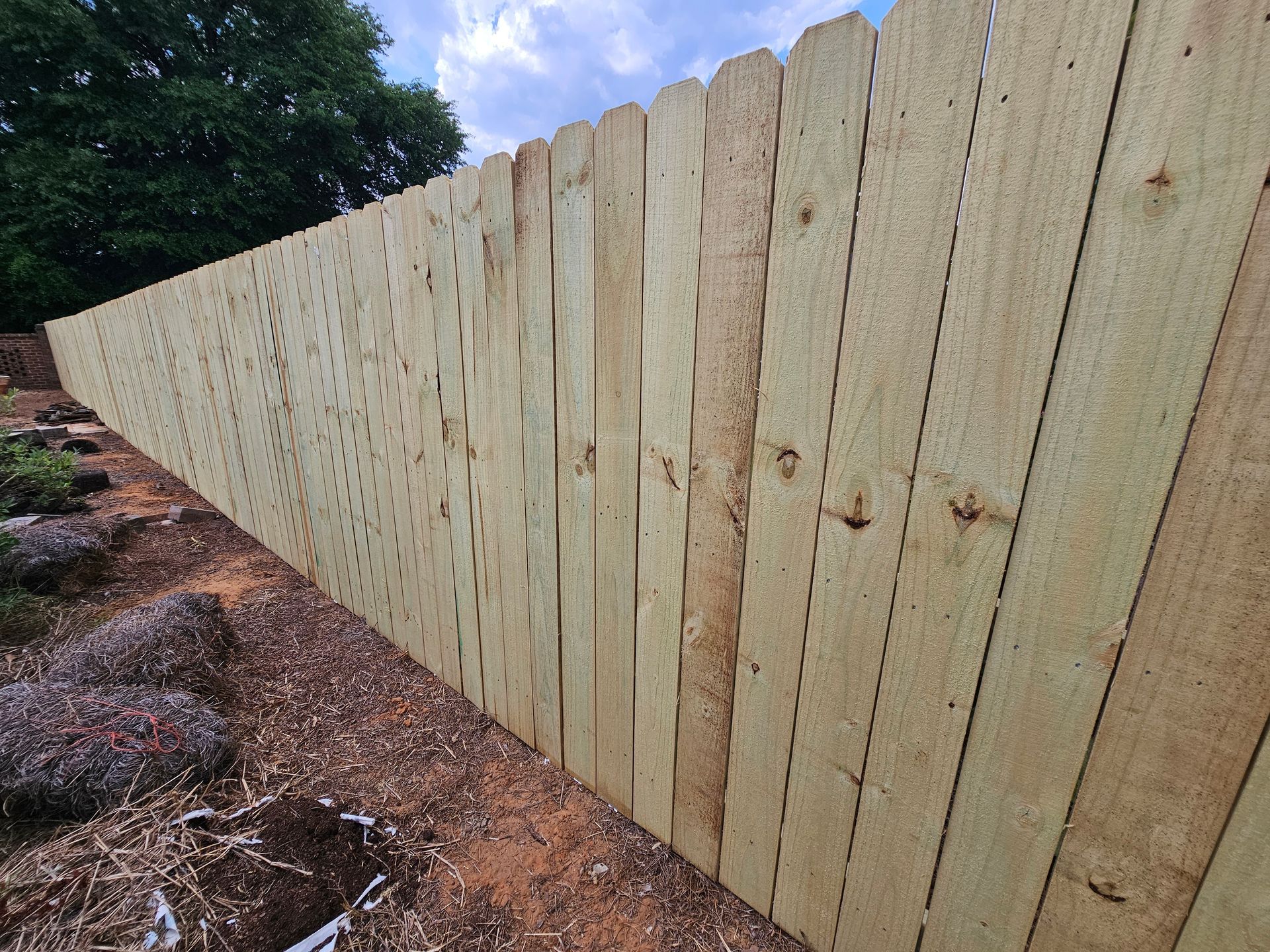 A wooden fence is sitting on top of a dirt hill.