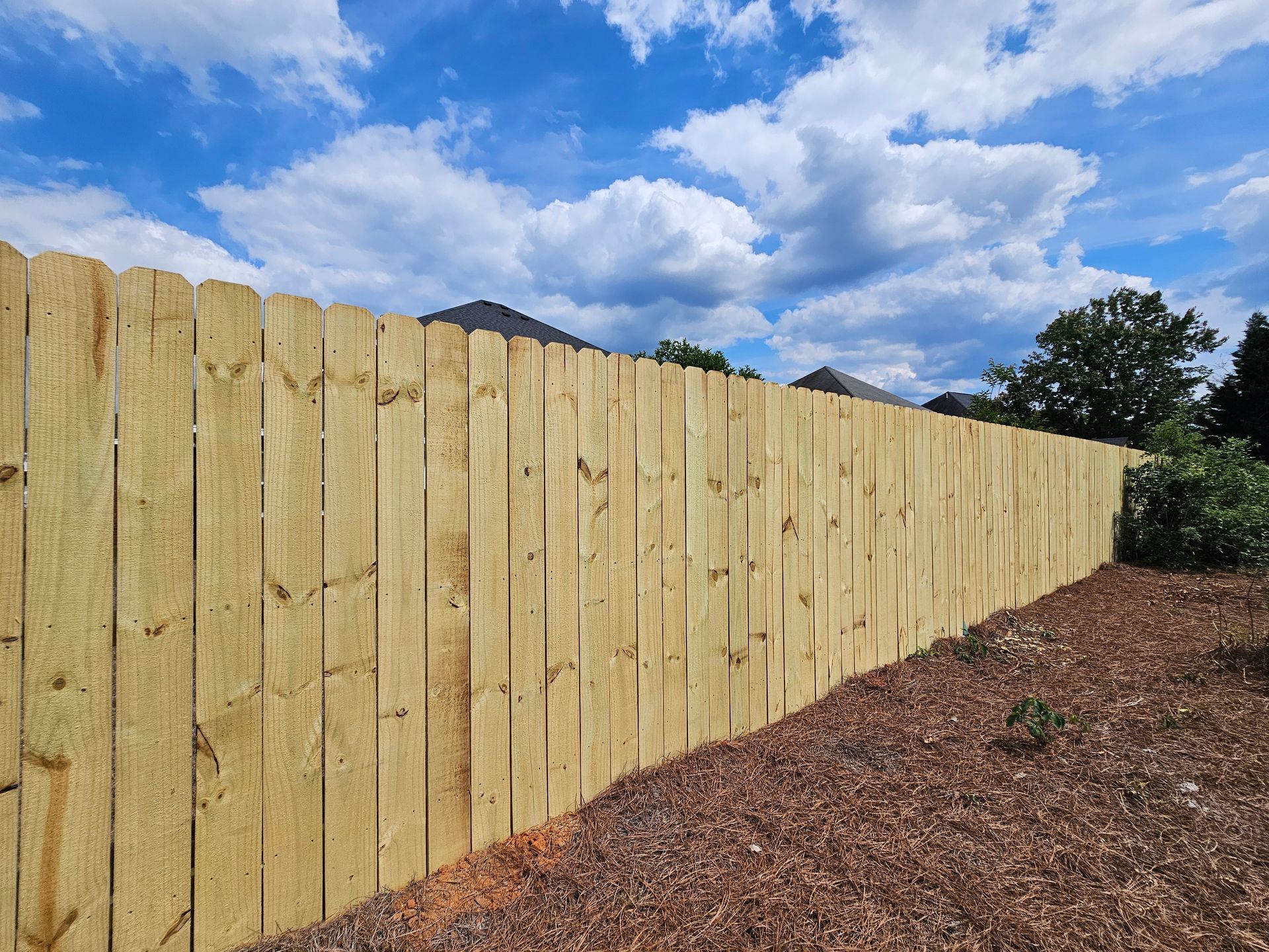 A wooden fence with a blue sky in the background
