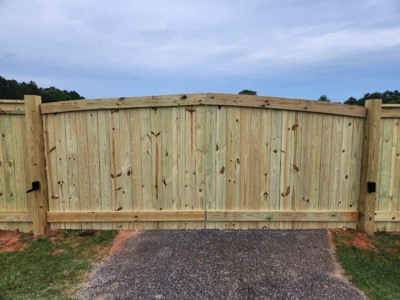 A close up of a wrought iron fence with a leaf on it.
