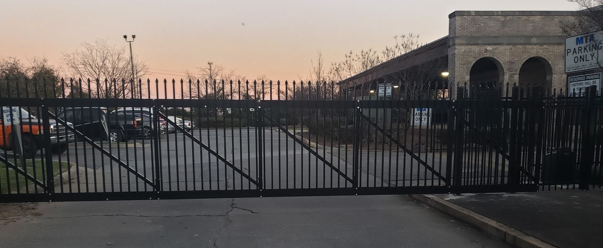 A wrought iron fence along a sidewalk in front of a building.
