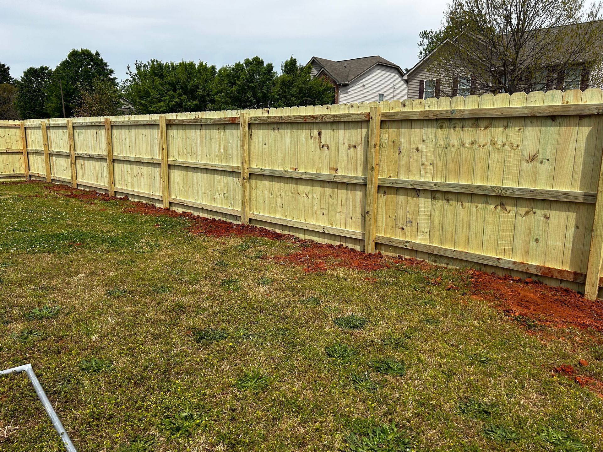 A wooden fence is sitting in the middle of a grassy field.