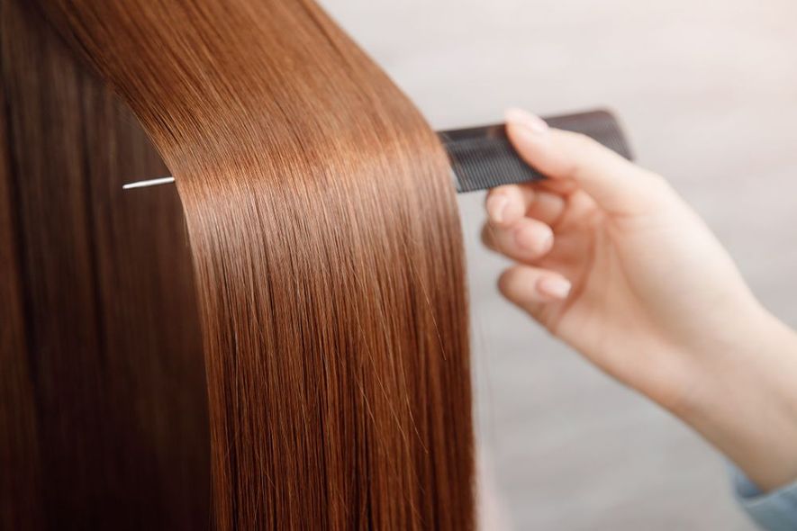 A woman is brushing her hair with a comb